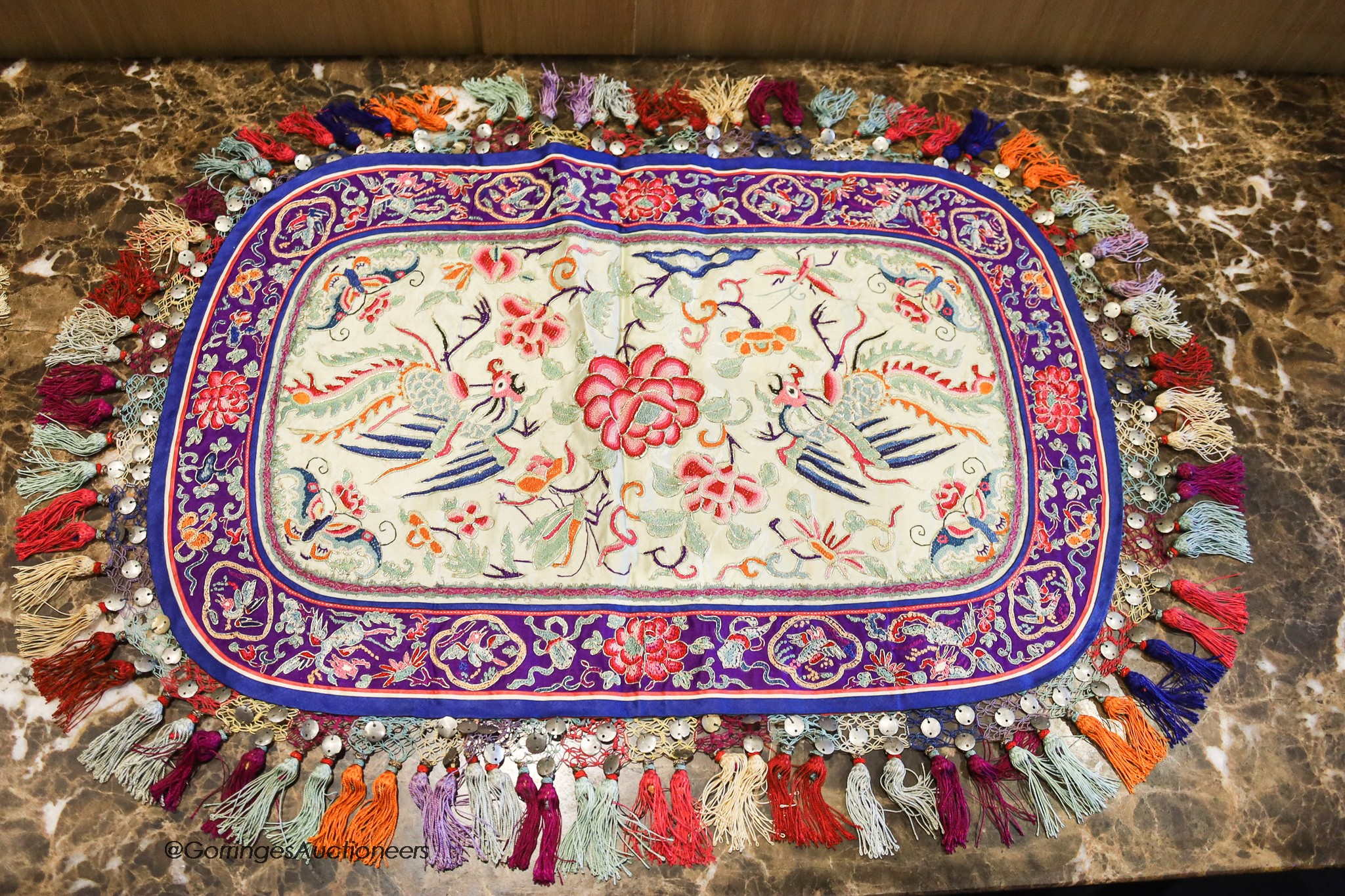 Four 20th century silk embroidered oval table centres edged with multi-coloured tassels, length 96cm